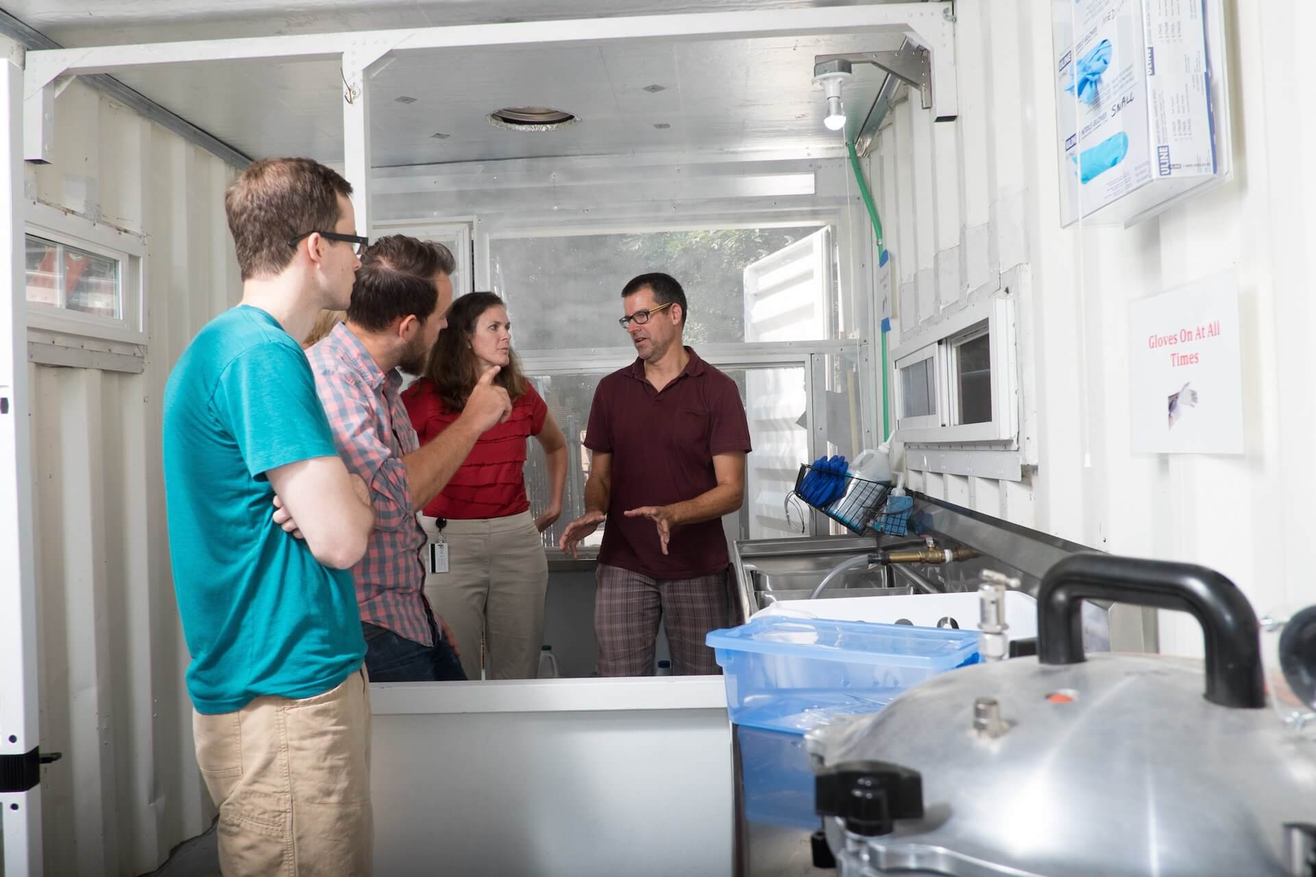 Rice University professors Maria Oden, second from right, and Douglas Schuler, right, give visitors a tour of the Sterile Box prototype. The unit was designed to sterilize and process surgical instruments in low-resource settings. (Credit: Jeff Fitlow)