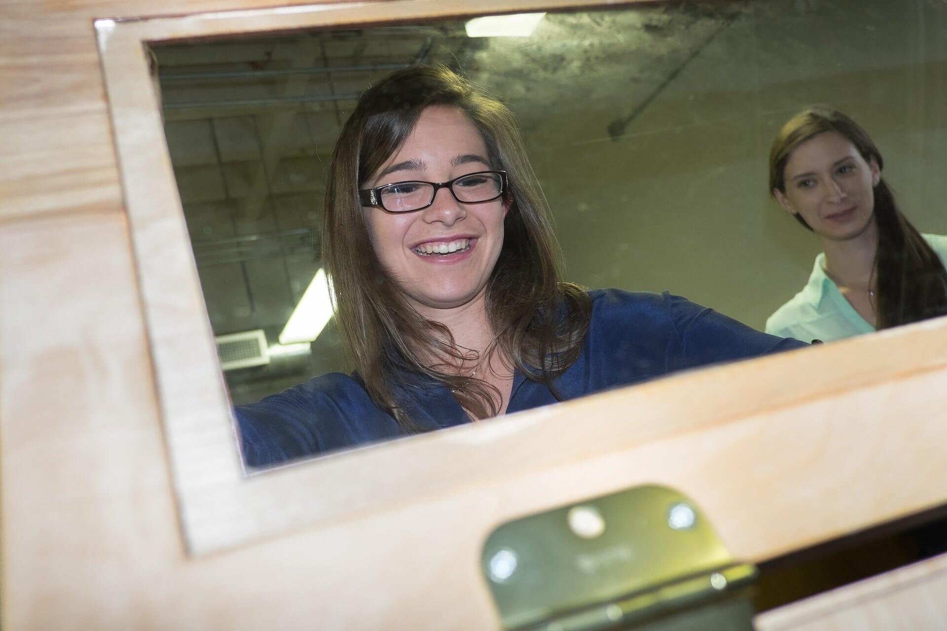 Rice University students Amanda Boone, left, and Carissa Livingston peer through the window of their senior engineering team's incubator which they designed to help newborns in developing countries recover from neonatal hypothermia. (Credit: Jeff Fitlow)