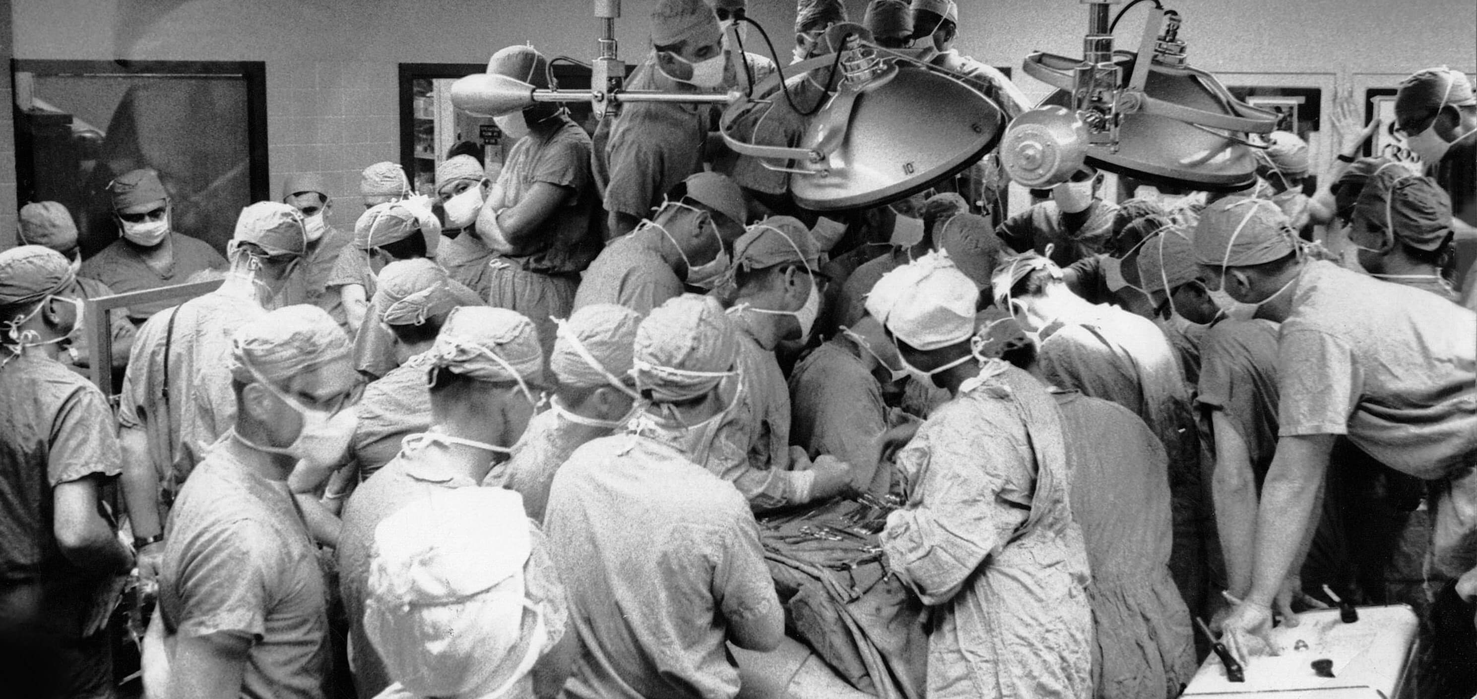Visiting surgeons from around the world gather to observe a procedure by Cooley’s team in the early days of the Texas Heart Institute. (Credit: Texas Heart Institute)