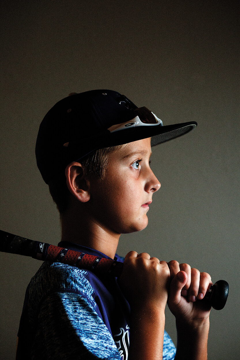 Ethan Page poses with his bat for a portrait at his home in Kingwood, Texas.