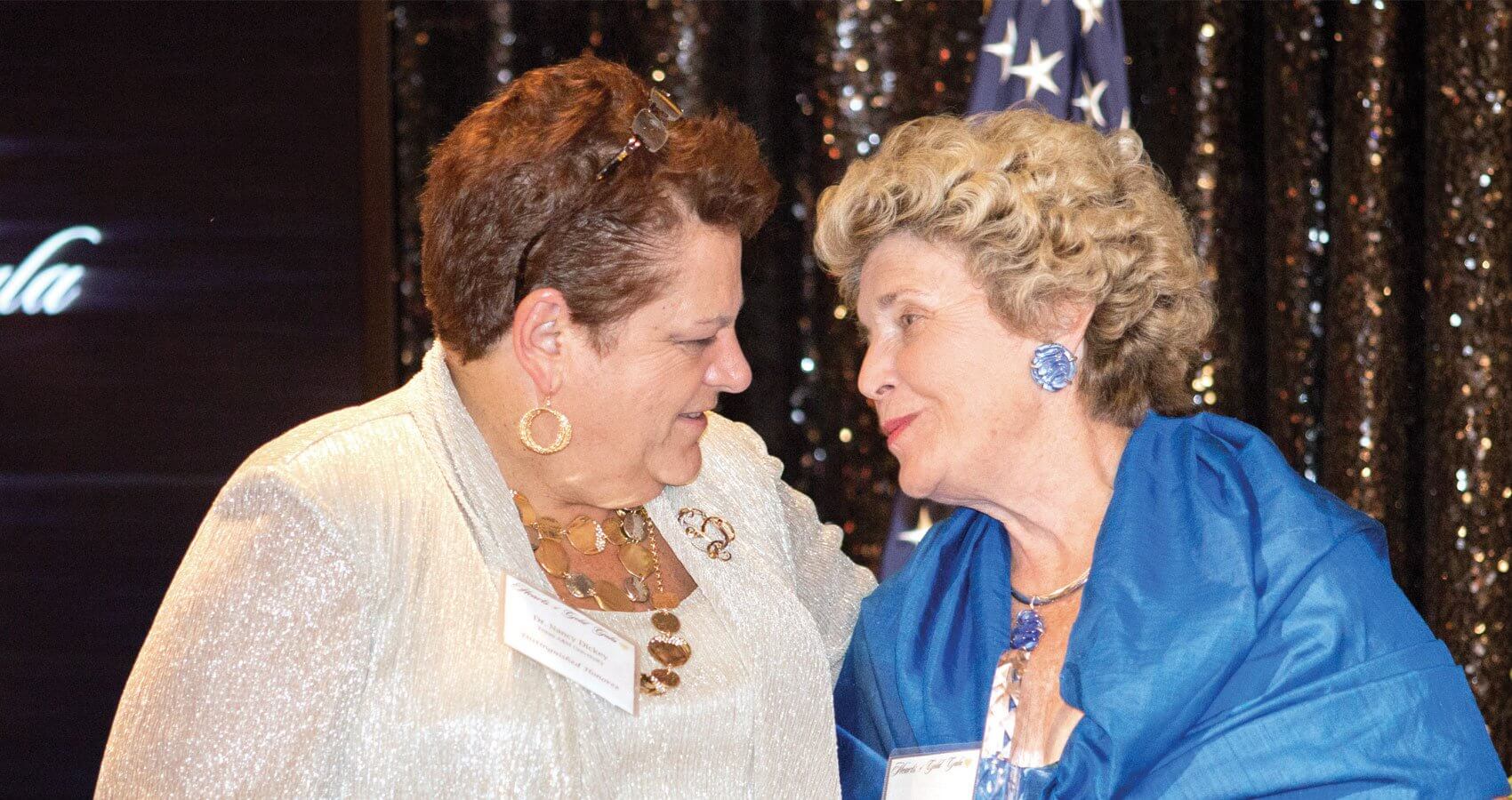 Honoree Nancy W. Dickey, M.D., and Karen Tellepsen, co-chair of the Hearts of Gold Gala, share a moment on stage