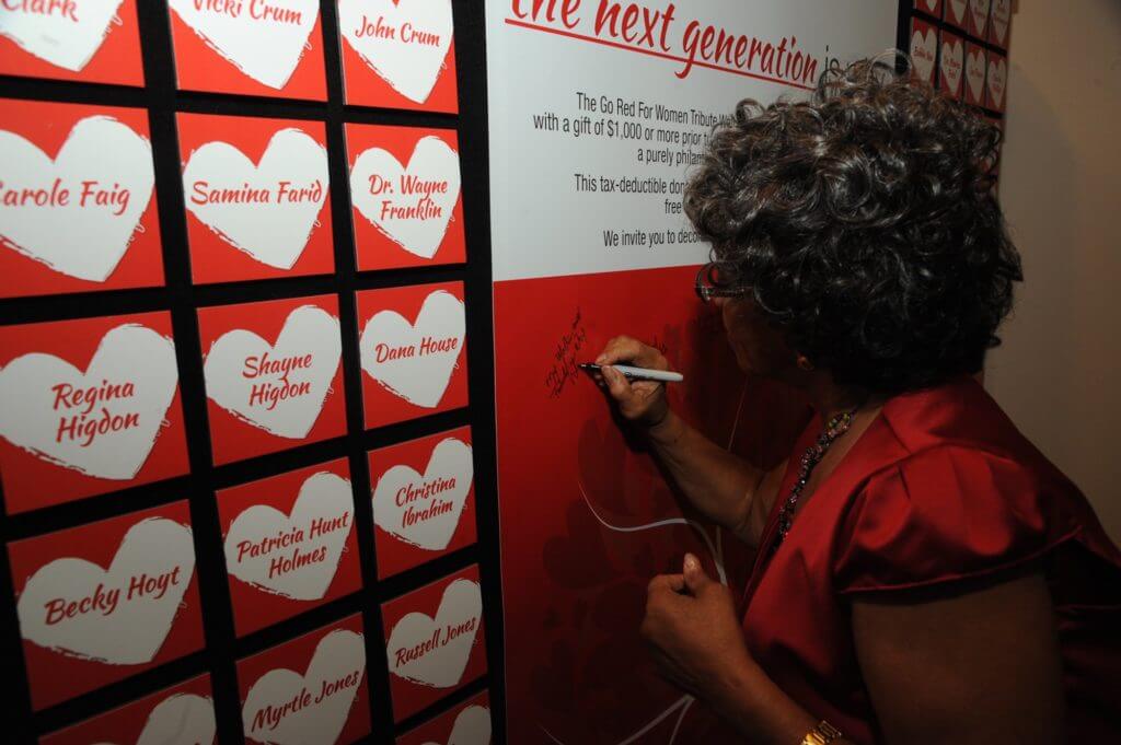 Luz Mouton signs the tribute wall