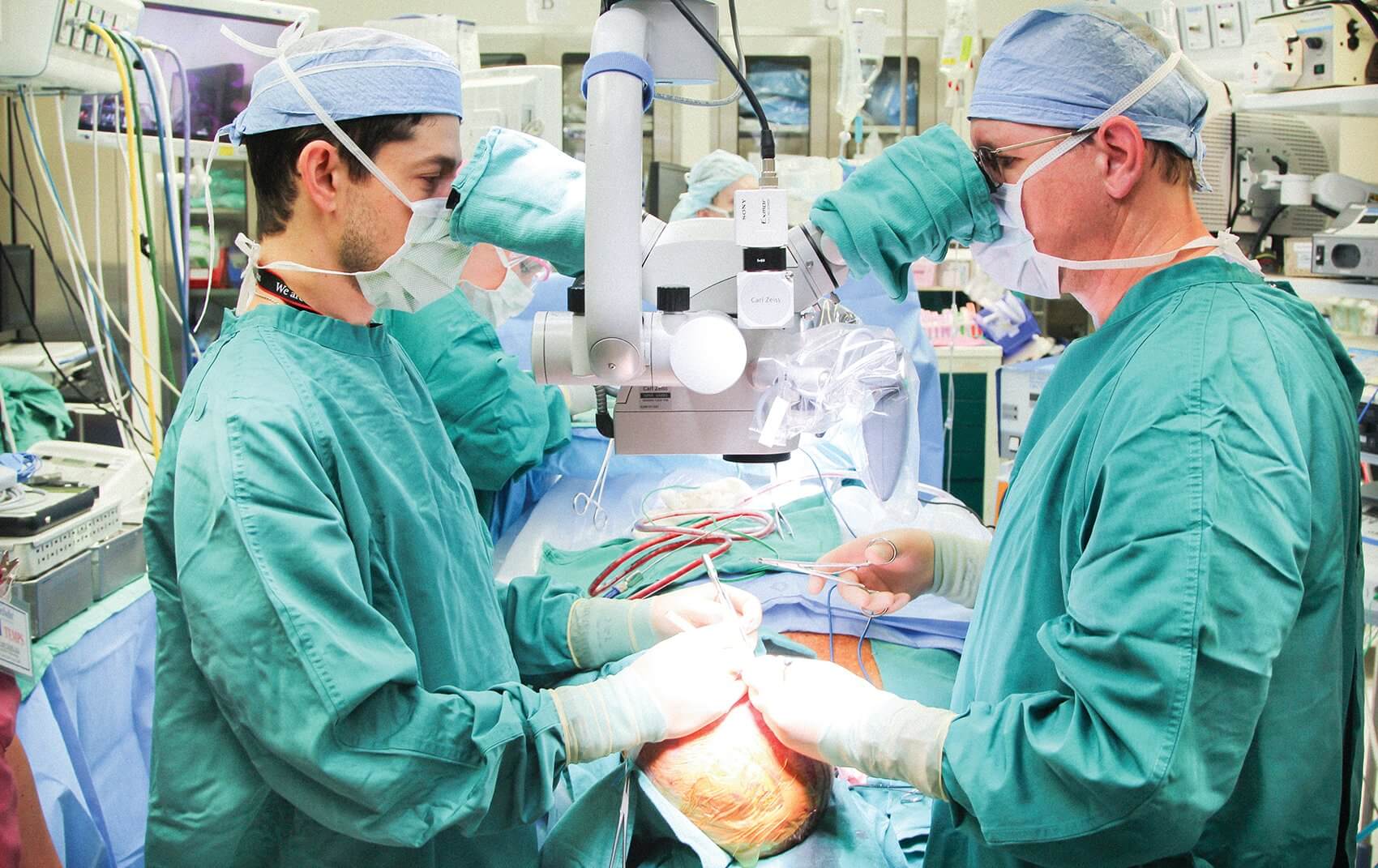 MD Anderson’s Jesse Selber, M.D., (left) and Houston Methodist’s Michael Klebuc, M.D., operate on Jim Boysen’s skull and scalp. (Credit: Houston Methodist Hospital)