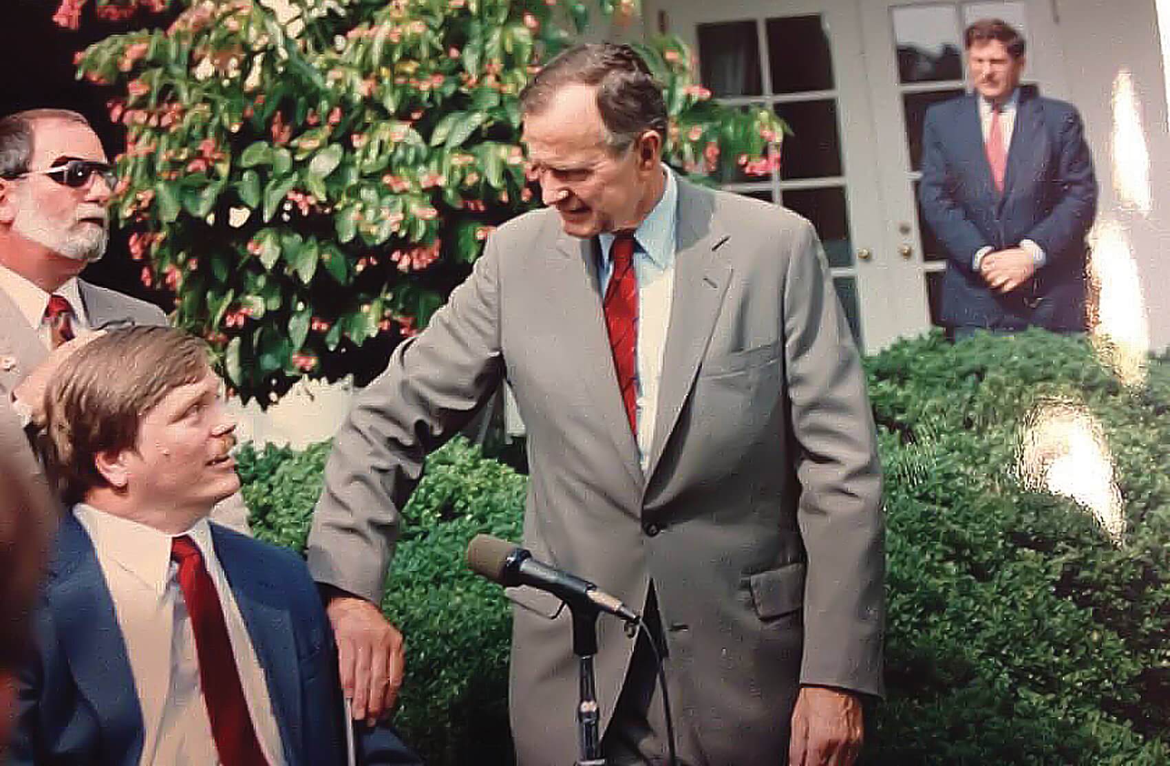 In 1991, Frieden and President Bush celebrate the first anniversary of the passage of the Americans with Disabilities Act at the White House Rose Garden. (Credit: Lex Frieden)