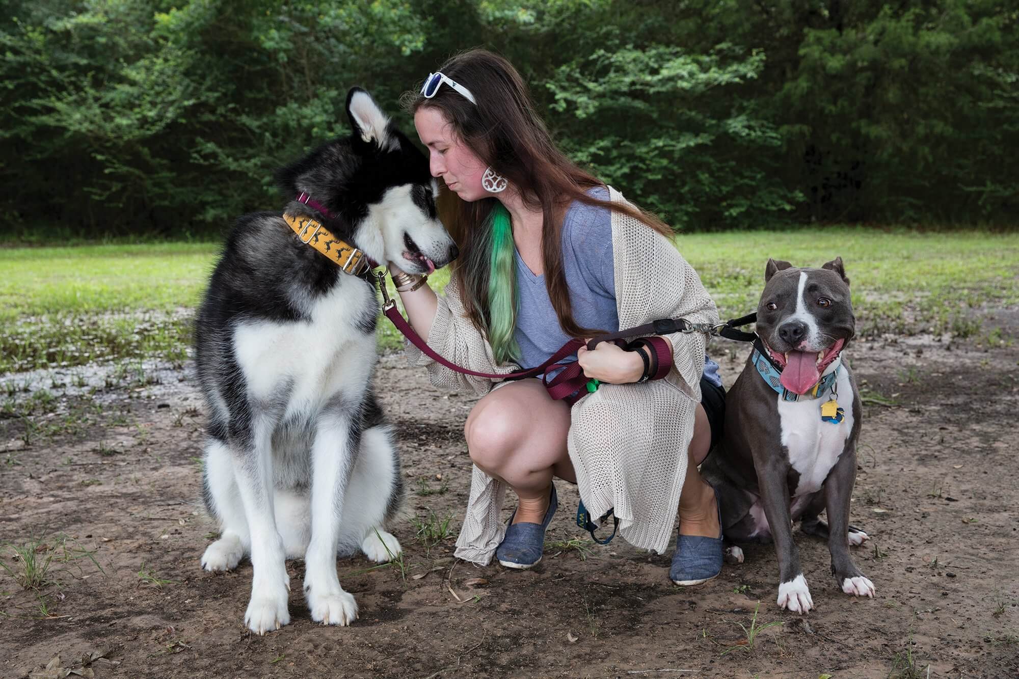 Sarrah Hannon, whose condition leaves her with excessively loose joints, with her dogs at a dog park near her home.