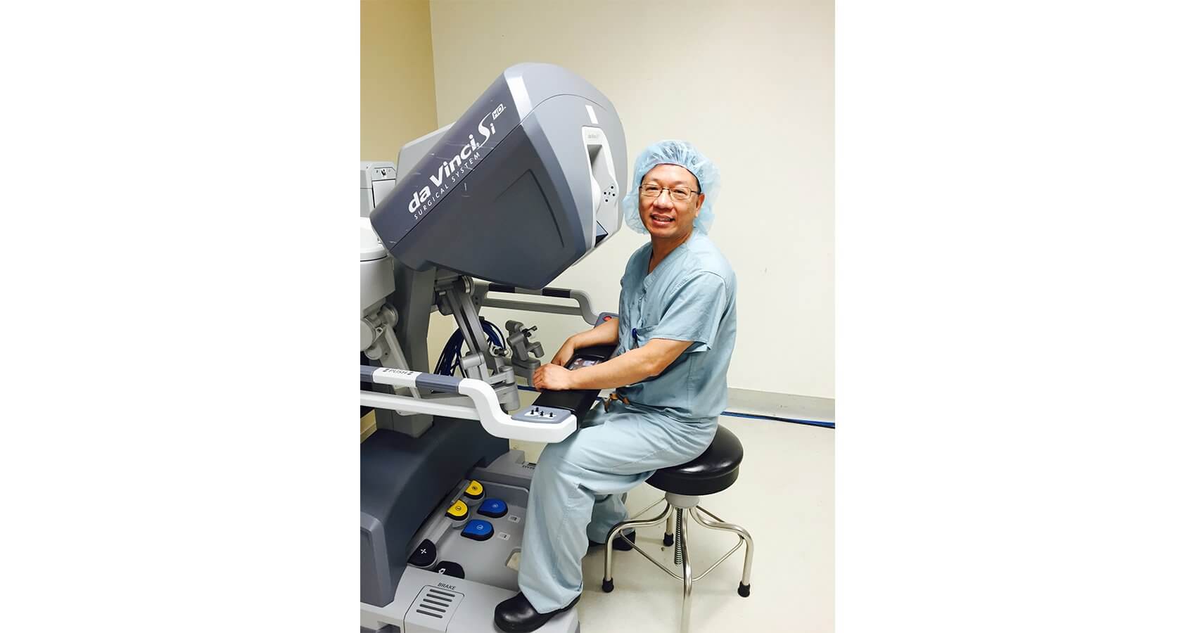 Xiaoming Guan, M.D., Ph.D., sits at the console of the da Vinci Si Surgical System.