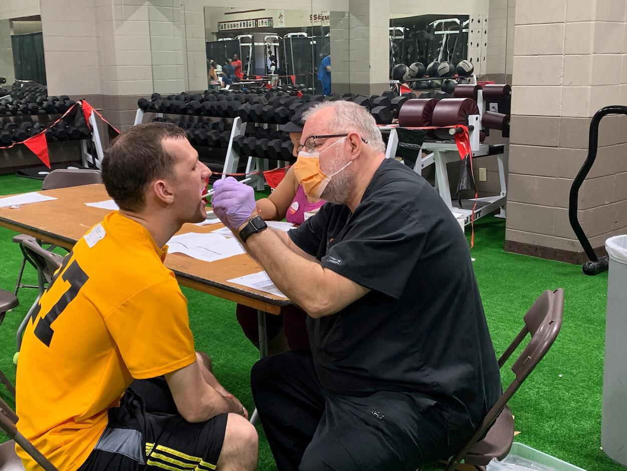 David Fray, D.D.S., UTHealth School of Dentistry associate professor, provides a flouride treatment for Special Olympics athlete Michael Motter.