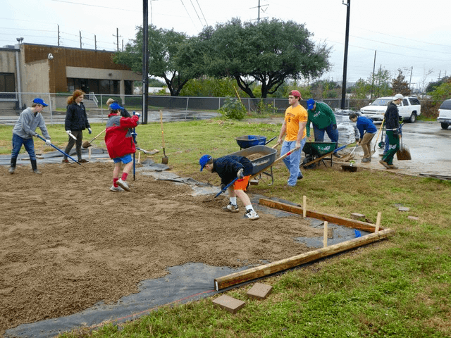 Jesse McMillan and his friends from Strake Jesuit College Preparatory prepare the ground at Nora's Home for a miniature golf course. (Photo courtesy of Sally McMillan)