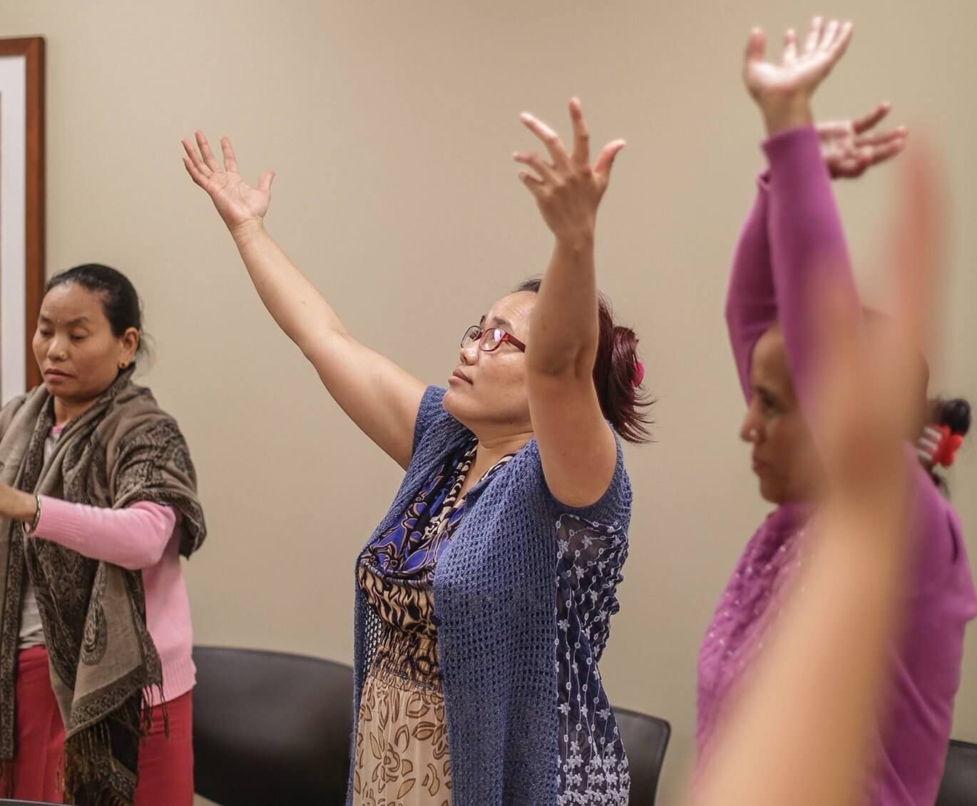 Bhutanese refugees perform breathing and movement exercises during a group therapy session.