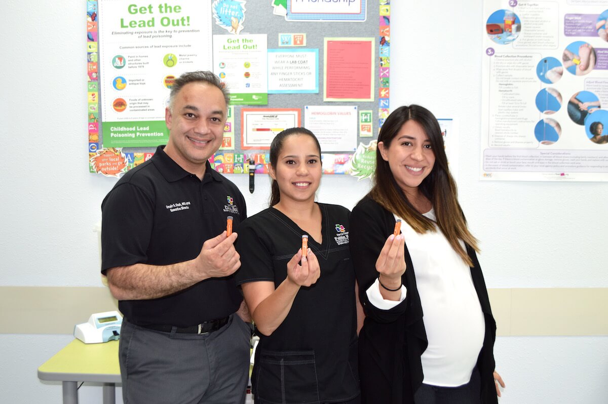 From left: Umair A. Shah, M.D., MPH, executive director of Harris County Public Health; medical assistant Yashira Padilla; and Nathalie Cardona, MPH, lead program team leader, hold up the finger-prick tool used in the lead screening process.